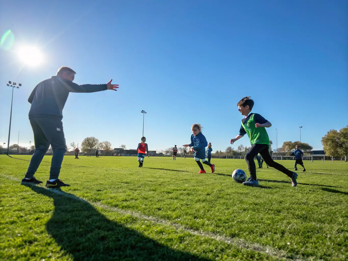 A vibrant image depicting a group of children participating in a soccer game, showcasing teamwork and physical activity in a community setting. The background includes supportive coaches and cheering parents.